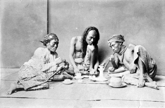 three males smoking opium